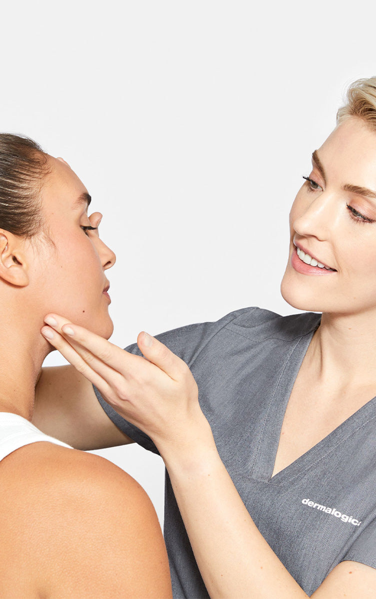 Skin therapist inspects woman's skin