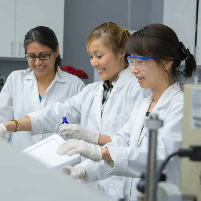 Women in lab coats work together