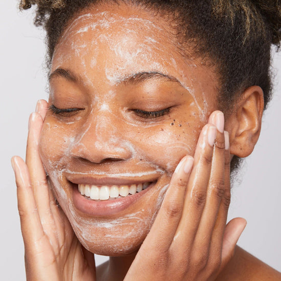 Young woman smiles as she applied skin care product